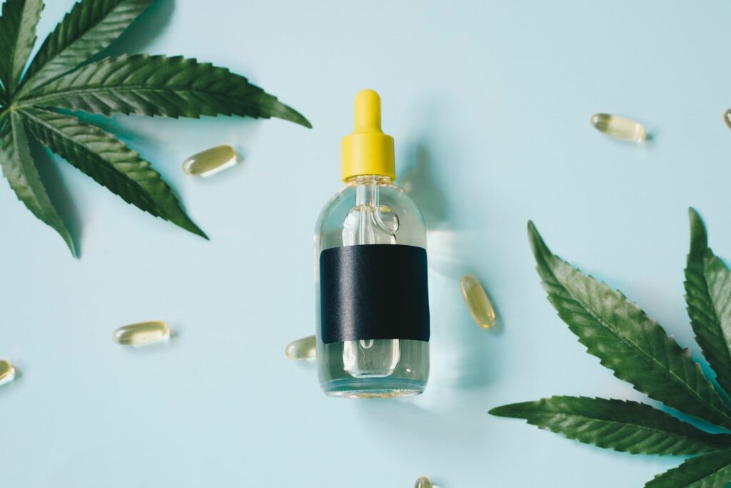 medical marijuana including leaves, pills, and tincture on blue background