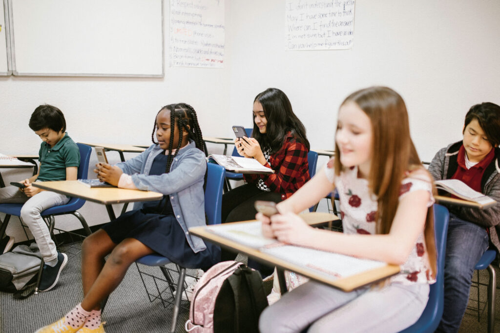 Children in a classroom on cell phones